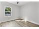 Empty bedroom with wood-look flooring and a window offering natural light at 12444 Sw 76Th Ln, Dunnellon, FL 34432