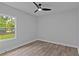 Bedroom with a window overlooking the trees, light-colored walls and modern ceiling fan at 12444 Sw 76Th Ln, Dunnellon, FL 34432