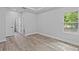 Bright bedroom featuring wood-look floors, a tray ceiling, and a window view of nature at 12444 Sw 76Th Ln, Dunnellon, FL 34432