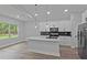 Bright modern kitchen featuring an island with bar seating, white cabinets, and stainless steel appliances at 12444 Sw 76Th Ln, Dunnellon, FL 34432
