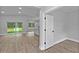 Living room featuring wood floors, modern doorframes, and an open layout that leads to the bright kitchen at 12444 Sw 76Th Ln, Dunnellon, FL 34432