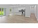 Open-concept living room showcasing hardwood floors connecting to a bright kitchen with a central island at 12444 Sw 76Th Ln, Dunnellon, FL 34432