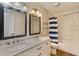 Modern bathroom featuring double sinks, marble countertops, and a tiled shower-tub combo at 12815 Katherine Cir, Clermont, FL 34711