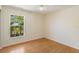 Bright bedroom with laminate floors, large window, ceiling fan, and white walls at 12815 Katherine Cir, Clermont, FL 34711