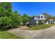 View of home exterior showing front yard, mature landscaping and a driveway to garages at 12815 Katherine Cir, Clermont, FL 34711