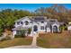 Beautiful two-story home with solar panels, a manicured lawn, and mature trees at 12815 Katherine Cir, Clermont, FL 34711