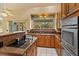 Bright kitchen with wooden cabinets, stainless steel appliances, and a large window at 12815 Katherine Cir, Clermont, FL 34711