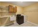 Laundry room with a utility sink, washer, dryer, and storage shelves at 12815 Katherine Cir, Clermont, FL 34711