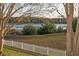 Scenic view of lake from backyard with white fence in foreground at 13131 Sandy Pine Ln, Clermont, FL 34711