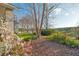 Scenic backyard view with mature trees, vibrant flowers, and a glimpse of the tranquil lake at 13131 Sandy Pine Ln, Clermont, FL 34711