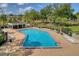 Community pool with lounge chairs, adjacent to picnic pavilion and tennis courts in the background at 13131 Sandy Pine Ln, Clermont, FL 34711