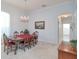 Dining room with a chandelier, wooden table with red cloth, carpet and view to hallway at 13131 Sandy Pine Ln, Clermont, FL 34711