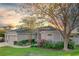 Beautiful home with a well-manicured lawn, stone accents, three car garage, and blooming flowers at 13131 Sandy Pine Ln, Clermont, FL 34711