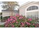 Close up of the landscaping showcasing blooming flowers near a home's arched window detail at 13131 Sandy Pine Ln, Clermont, FL 34711