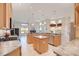 Well-lit kitchen overlooking the Gathering room, features wood cabinetry and a central breakfast bar at 13131 Sandy Pine Ln, Clermont, FL 34711