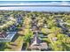 Aerial view of a neighborhood with single-Gathering homes, mature trees, and a scenic lake in the background, creating a peaceful setting at 13421 Via Roma Cir, Clermont, FL 34711