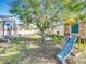 Large back yard features a large tree, a play set, and a sunroom at 13421 Via Roma Cir, Clermont, FL 34711