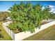 The backyard has a white fence, mature trees, and a play area at 13421 Via Roma Cir, Clermont, FL 34711