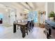 Bright dining room featuring a wooden table, modern light fixture, and large window overlooking the front yard at 13421 Via Roma Cir, Clermont, FL 34711