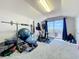 Bright exercise room features gym equipment, carpeted floor, and sliding doors to balcony perfect for health and wellness at 13421 Via Roma Cir, Clermont, FL 34711