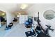 Exercise room featuring workout equipment, carpet, and natural light, ideal for maintaining an active lifestyle at home at 13421 Via Roma Cir, Clermont, FL 34711