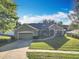 Inviting single-story home with lush lawn, two car garage, and inviting front entrance at 13421 Via Roma Cir, Clermont, FL 34711