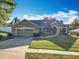 Attractive single-story home with lush lawn, two car garage, and inviting front entrance at 13421 Via Roma Cir, Clermont, FL 34711