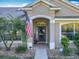 Welcoming front entrance with decorative plants, a welcome sign, and storm door at 13421 Via Roma Cir, Clermont, FL 34711