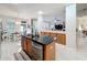 Kitchen island with a sink and stainless steel appliances, seamlessly connected to the dining and living areas at 13421 Via Roma Cir, Clermont, FL 34711