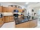 Well-lit kitchen with granite countertops, stainless steel appliances, and ample cabinet space at 13421 Via Roma Cir, Clermont, FL 34711