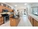 Well-lit kitchen with stainless steel appliances, a central island, and granite countertops with wood cabinets at 13421 Via Roma Cir, Clermont, FL 34711