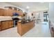 Modern kitchen with wooden cabinetry, stainless appliances, and a black granite island at 13421 Via Roma Cir, Clermont, FL 34711