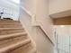 Carpeted staircase leading to upper level, showcasing neutral tones and classic architectural details at 13421 Via Roma Cir, Clermont, FL 34711