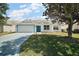 Welcoming single-story home with lush front lawn, attached garage, and bright blue front door at 1419 Segovia Pl, The Villages, FL 32162