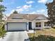 Charming single-story home featuring a two-car garage, manicured lawn, and inviting curb appeal at 1419 Segovia Pl, The Villages, FL 32162