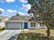 Charming single-story home with a well-manicured lawn and inviting curb appeal, featuring a bright blue front door at 1419 Segovia Pl, The Villages, FL 32162