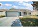 Charming single-story home with a well-manicured lawn and inviting curb appeal, featuring a bright blue front door at 1419 Segovia Pl, The Villages, FL 32162