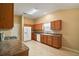 Open kitchen with a white refrigerator, wood cabinets, and a tiled floor for an inviting space at 1419 Segovia Pl, The Villages, FL 32162