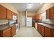 Well-lit kitchen with warm wood cabinets, ample counter space, and white appliances at 1419 Segovia Pl, The Villages, FL 32162