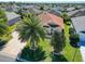 Well-maintained home featuring lush landscaping, mature palms, and a barrel tile roof at 1430 Hillstream St, The Villages, FL 32163