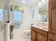 Bathroom featuring granite countertops, wooden cabinetry, and a separate glass-enclosed shower at 1430 Hillstream St, The Villages, FL 32163