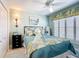 Bedroom featuring light blue walls, shuttered windows, and a comfortable bed with floral accents at 1430 Hillstream St, The Villages, FL 32163