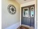 Close-up of the elegant front door with decorative glass and a welcoming 'Hello Summer' doormat at 1430 Hillstream St, The Villages, FL 32163