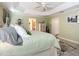 Spacious bedroom featuring a tray ceiling, neutral colors, and a view into the attached bathroom at 1430 Hillstream St, The Villages, FL 32163