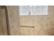 Bathroom showcasing tiled walls, glass block window, and a modern grab bar at 1430 Hillstream St, The Villages, FL 32163