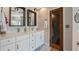 Bathroom featuring a double vanity with framed mirrors, decorative light fixtures, and plenty of cabinet storage at 16109 Hillside Cir, Montverde, FL 34756