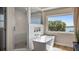 Bright bathroom boasts a modern soaking tub next to a sunlit window and a glass-enclosed tiled shower at 16109 Hillside Cir, Montverde, FL 34756