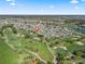 Scenic aerial view of a golf course community with lush greenery, houses, and a lake at 1726 Augustine Dr, The Villages, FL 32159