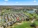 Stunning aerial view showcases a home's enviable location within a lush golf course and a view of distant city buildings at 1726 Augustine Dr, The Villages, FL 32159