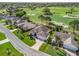 Aerial view of a well-maintained home, green lawns, and landscaping, with a golf course in the background at 1726 Augustine Dr, Lady Lake, FL 32159